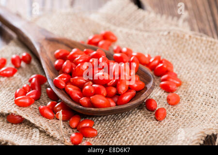 Quelques baies de Goji frais (également connu sous le nom de Wolfberry) vintage sur fond de bois Banque D'Images