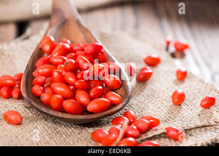 Quelques baies de Goji frais (également connu sous le nom de Wolfberry) vintage sur fond de bois Banque D'Images