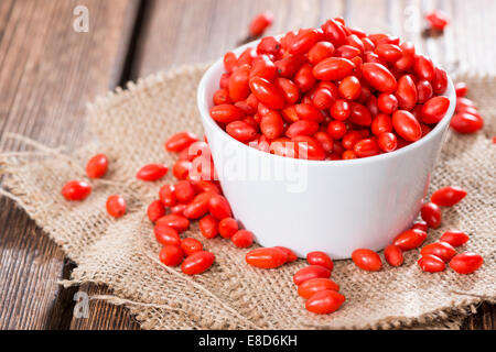 Quelques baies de Goji frais (également connu sous le nom de Wolfberry) vintage sur fond de bois Banque D'Images