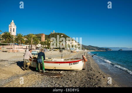 Les pêcheurs avec un bateau de pêche sur la plage de Noli, Riviera di Ponente, Ligurie, Italie Banque D'Images