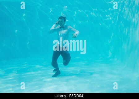 Young man swimming underwater Banque D'Images