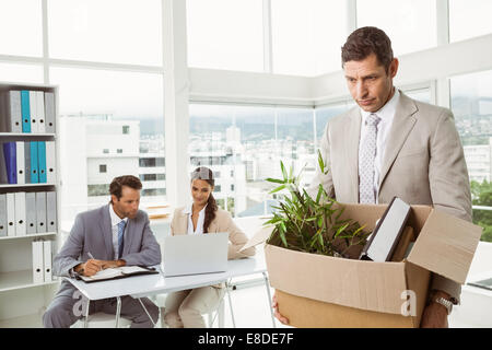 Businessman carrying ses affaires dans la case Banque D'Images