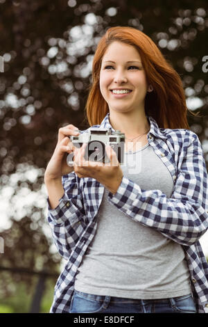 Femme portant des jeans et chemise à tenir l'appareil photo Banque D'Images
