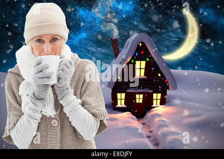 Image composite de femme dans des vêtements chauds holding mugs Banque D'Images