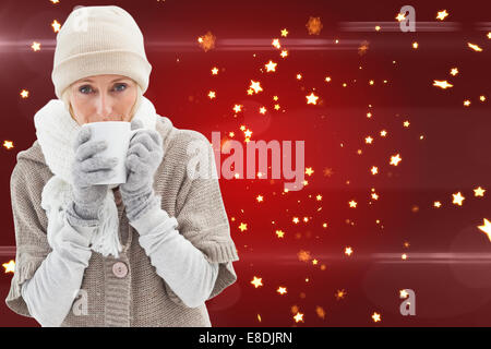 Image composite de femme dans des vêtements chauds holding mugs Banque D'Images