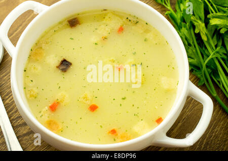 Soupe aux champignons avec des croûtons dans un bol en céramique blanc et fines herbes Banque D'Images