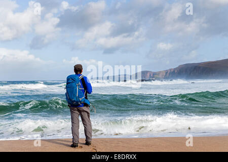 Walker et mer déchaînée, Sandwood Bay au nord ouest de l'Ecosse UK Banque D'Images