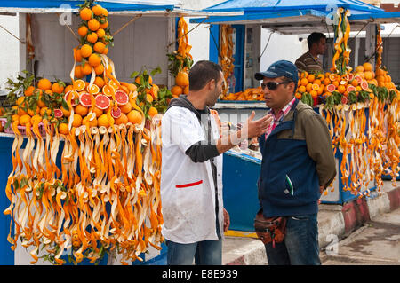 Portrait horizontal de deux hommes discutant lors d'un décrochage de jus d'orange à Essaouira Banque D'Images