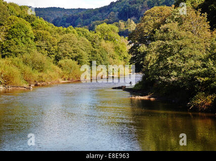 Tronçon de la rivière Wye dans Monmouthshire Galles du Sud avec un pêcheur de mouche sur la banque loin Banque D'Images