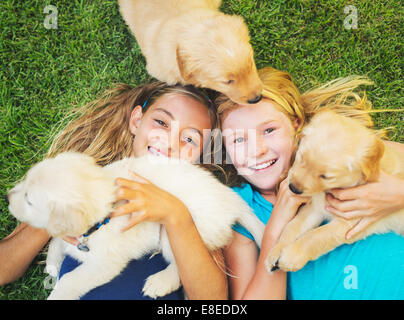 Adorable jolies jeunes femmes jouant et serrant les chiots Banque D'Images