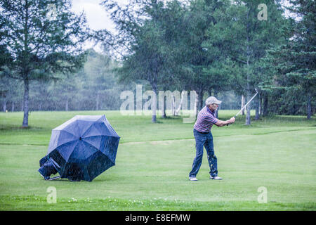 Un jour de pluie golfeur Swigning dans le Fairway (motivation concept) Banque D'Images