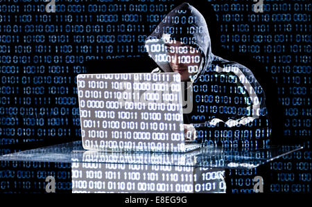 Hacker de la saisie sur un ordinateur portable avec un code binaire en arrière-plan Banque D'Images