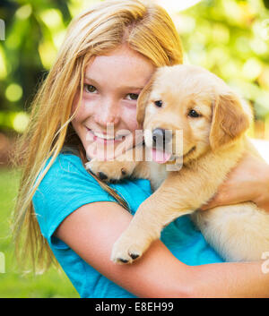 Adorable jeune fille jouant et serrant les chiots Banque D'Images