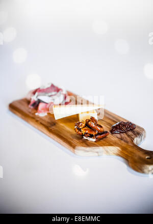 Plateau de fromages traditionnels portugais avec les pacanes et le prosciutto sur un compteur blanc Banque D'Images