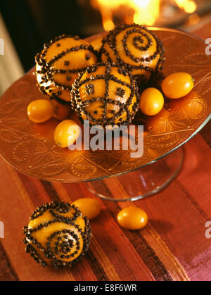 Close-up de pomanders fabriqués à partir de verre de girofle clous oranges on cake stand avec qumquats Banque D'Images