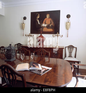 Chaises de style Régence et tableau blanc en salle à manger avec grande photo ci-dessus avec candélabres en laiton Banque D'Images