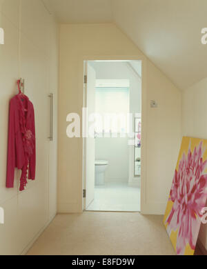 Atterrissage avec neutre moderne photo et cardigan rose sur le mur et ouvrir la porte d'une salle de bains privative Banque D'Images