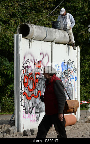 Mason Frank Huhndt est situé sur une partie du mur de Berlin qui a été conservé comme un mémorial près du Mémorial du Mur de Berlin et les réparations Voir Glienicker brut endommagé des patches en Gross Glienicke, Allemagne, 24 septembre 2014. L'areal à proximité de l'ancienne frontière entre l'Allemagne de l'Ouest et la RDA subit actuellement des rénovations pour la somme de 80 000 euros et devrait être inauguré à temps pour le 25e anniversaire de la chute du mur le 09 novembre 2014. Photo : RALF HIRSCHBERGER/DPA Banque D'Images