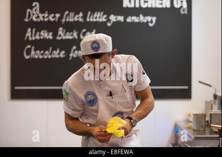 Earls Court, London UK. 7 octobre 2014. Le Restaurant Cuisine Concours National jeunes tient le Chef de l'année, la 4ème Guilde du concours des chefs pour les chefs de 18 à 23 avec 8 concurrents chefs vivent dans la finale. Julien Pickerskill de la Chambre des communes de Londres la préparation de plat principal. Credit : Malcolm Park editorial/Alamy Live News. Banque D'Images