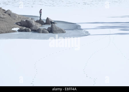 Femme avec chien debout près du lac gelé, Colorado, États-Unis Banque D'Images