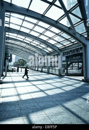 Japon, Tokyo, l'homme marchant à travers passerelle piétonne Banque D'Images