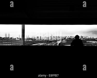 Silhouette d'une personne à la recherche à l'horizon de la ville, São Paulo, Brésil Banque D'Images