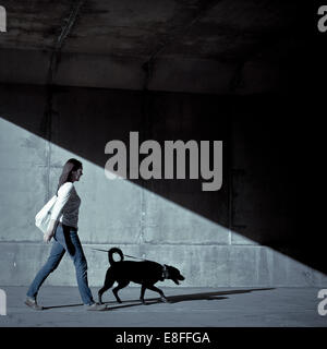 Woman walking with dog sous le pont Banque D'Images