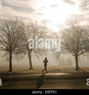 Silhouette d'une femme qui court dans le parc, Angleterre, Royaume-Uni Banque D'Images
