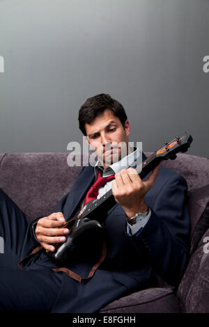 Businessman playing toy guitar Banque D'Images