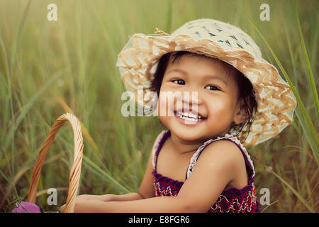 Portrait of smiling girl sitting in grass Banque D'Images