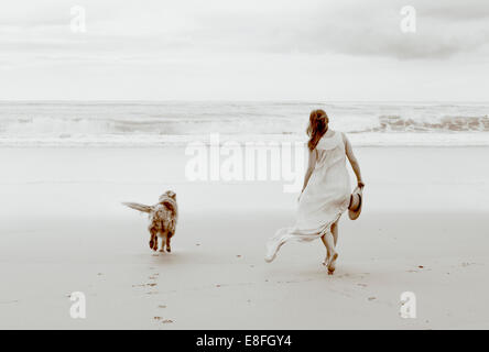 Femme marchant sur la plage avec son chien, Afrique du Sud Banque D'Images