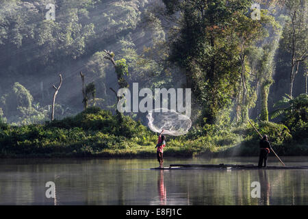 L'Indonésie, Java ouest, Karawang Gunung in situ, Man throwing filet de pêche dans l'eau Banque D'Images