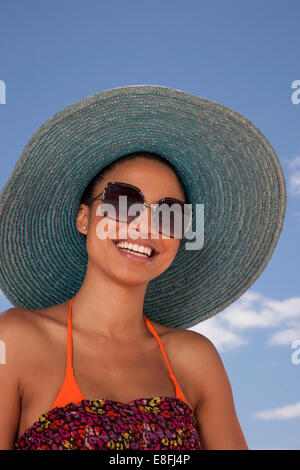 Portrait d'une femme souriante dans un chapeau de paille et des lunettes de soleil, Cape Town, Western Cape, Afrique du Sud Banque D'Images