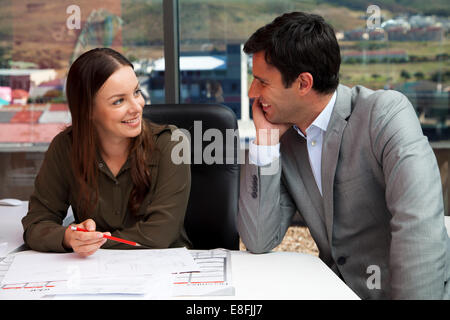 Businessman sitting in an office talking Banque D'Images