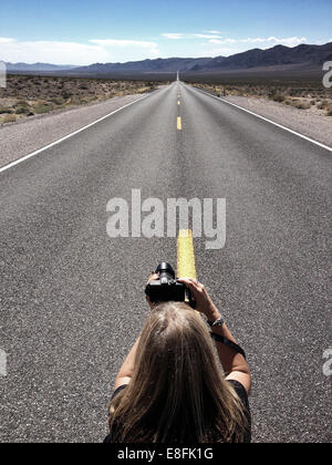 Femme prenant la photo de la route vide, Californie, États-Unis Banque D'Images