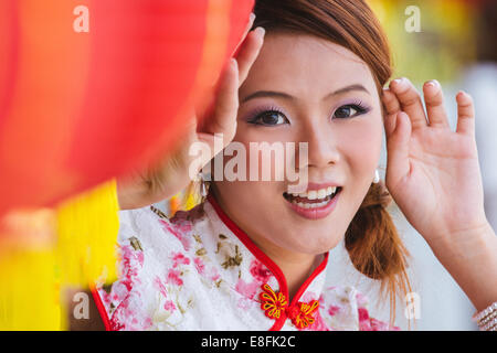 Portrait of young woman standing by lanternes de papier Chinois Banque D'Images