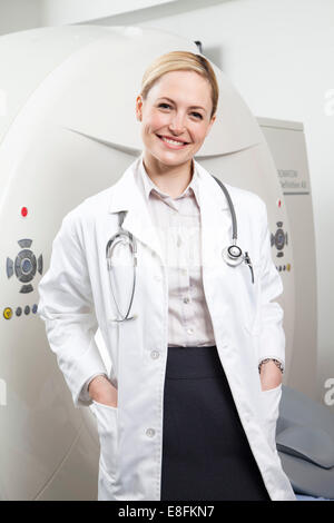 Portrait d'un médecin souriant debout à côté d'un scanner IRM dans un hôpital Banque D'Images