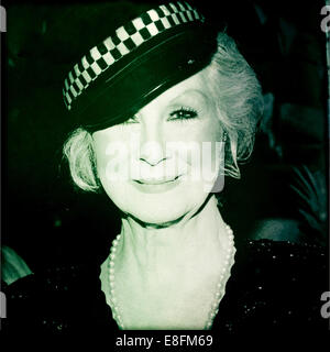 Portrait d'une femme souriante portant un chapeau de police Banque D'Images