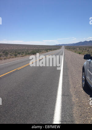 Voiture garée sur une route du désert, Nevada, États-Unis Banque D'Images