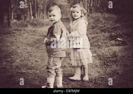 Garçon et fille debout dans la forêt, Angleterre, Royaume-Uni Banque D'Images