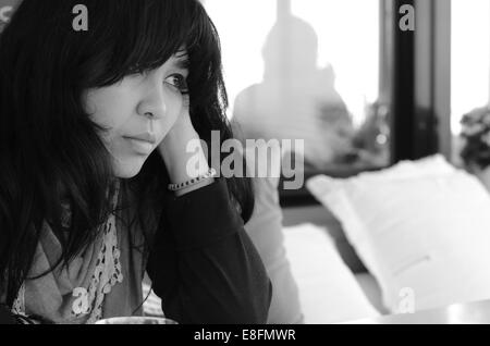 Portrait de femme assise sur un canapé Banque D'Images