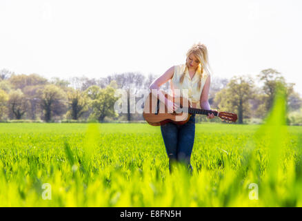 Le chanteur country féminin dans grass field Banque D'Images