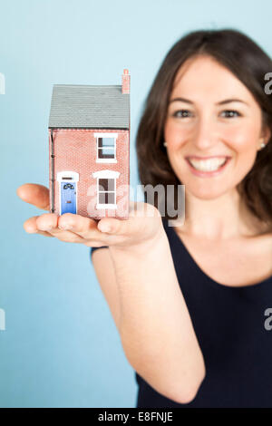 Young woman holding model house dans la paume de la main Banque D'Images