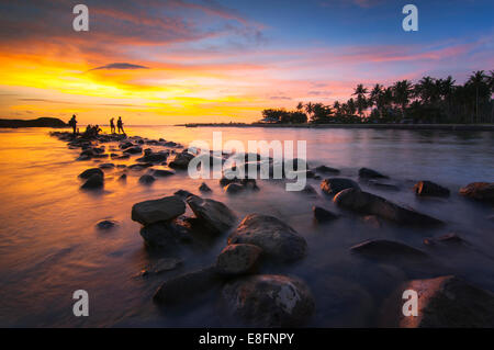 L'Indonésie, Sumatra, l'Ouest de Sumatra, Silhouette de personnes sur la plage au coucher du soleil Banque D'Images