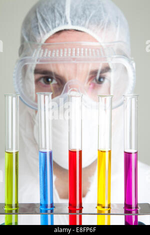 Scientist looking at test tubes in rack Banque D'Images