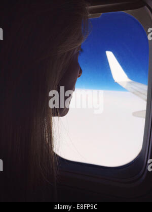 Femme à la fenêtre de l'avion Banque D'Images