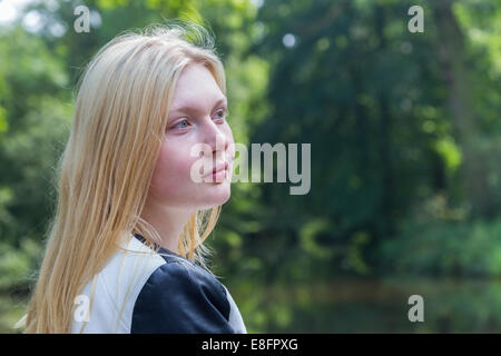 Tête de jeune fille blonde avec de l'eau et arbres Banque D'Images