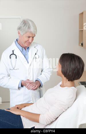 Doctor talking to female patient in examination room Banque D'Images