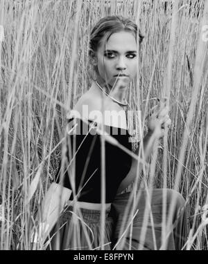 Femme de se cacher dans l'herbe haute Banque D'Images