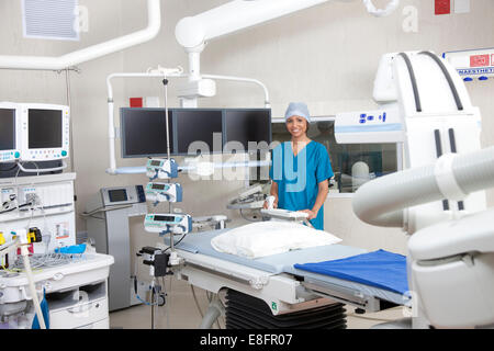 Doctor standing en salle d'opération avec le système d'imagerie robotique Banque D'Images